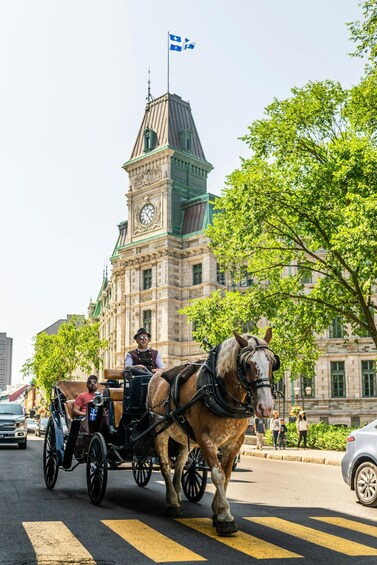 A horse-drawn carriage on a city street with a historic building in the background. 1