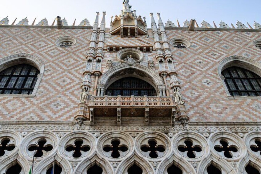 A building with a patterned facade, ornate arches, and a detailed central section. 4