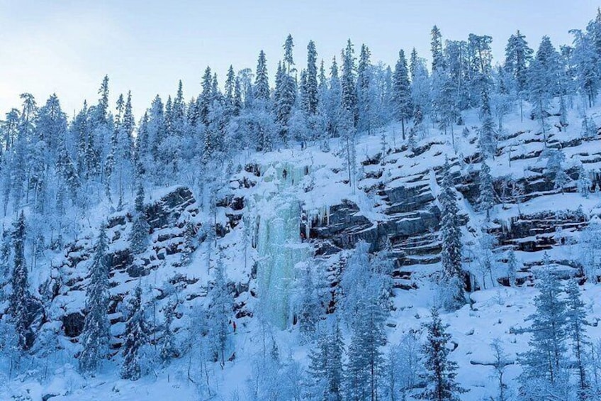 A snow-covered forest with a rocky hillside and icicles. 1