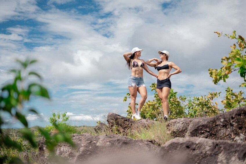 Two people standing on a rocky outcrop with a cloudy sky in the background. 5