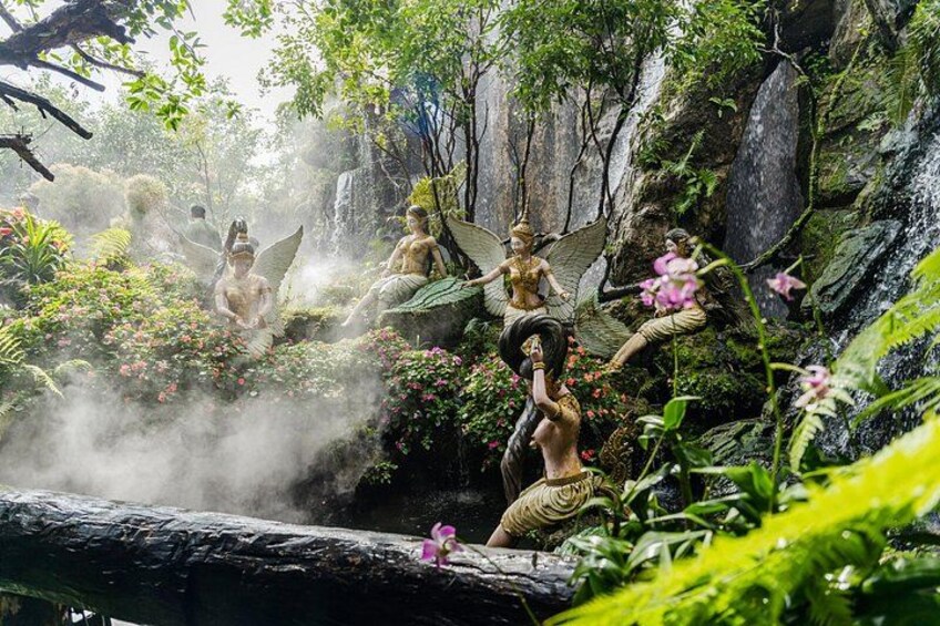 A garden with statues of fairies and a waterfall. 4