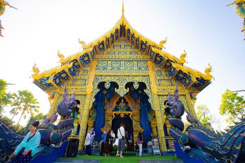 A temple with ornate blue and gold decorations, featuring statues of mythical creatures. 3