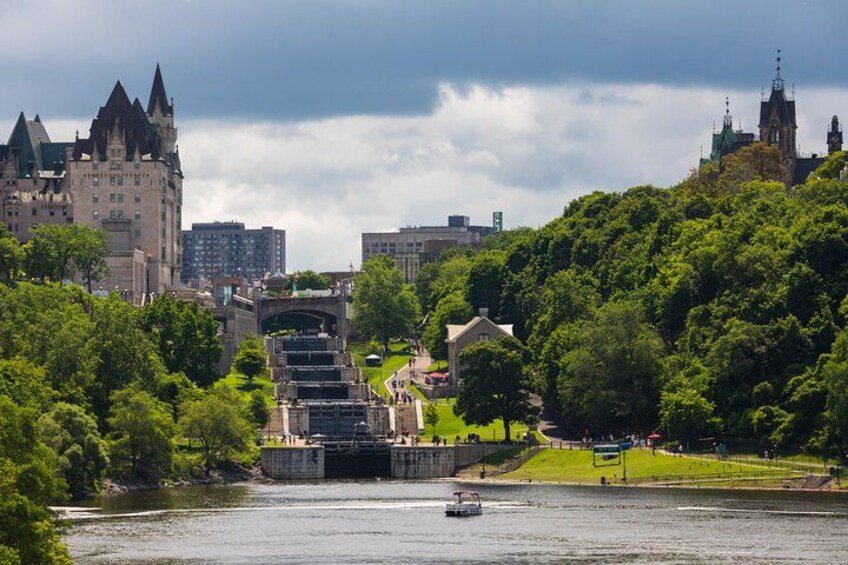 A river with a boat, a castle-like building, and a park with trees. 5