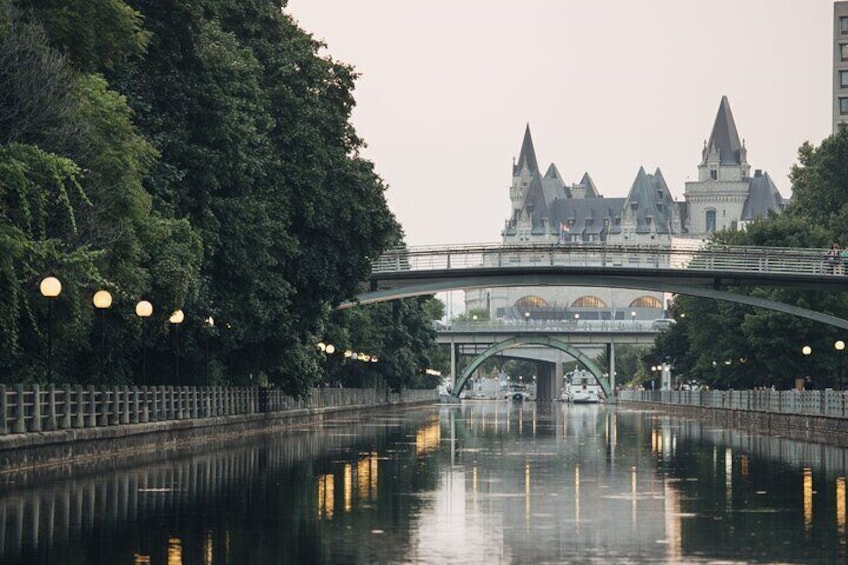 A river with a bridge, trees, and a castle-like building in the background. 4