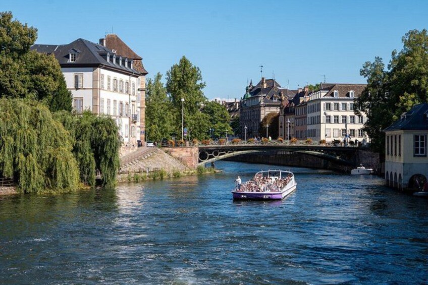 A river with a boat, buildings, and a bridge. 4