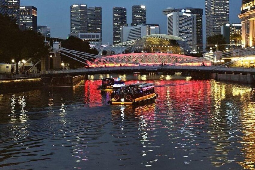 A river with a boat, a bridge, and a city skyline at dusk. 2