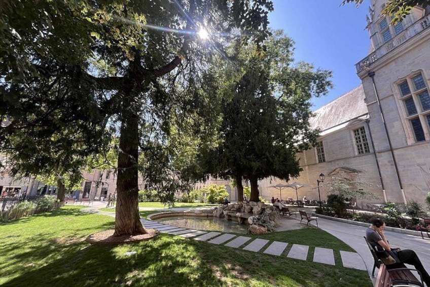 A courtyard with trees, a stone pathway, and a building with large windows. 4