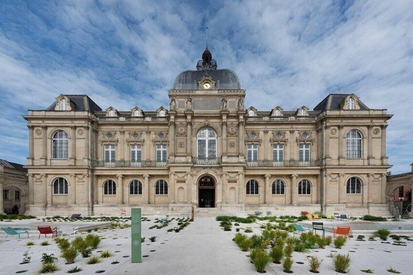 A large, historic building with a central dome and symmetrical windows. 2