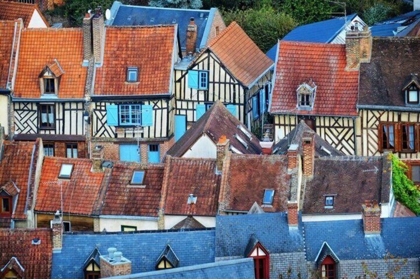 A cluster of traditional timber-framed buildings with steeply pitched roofs. 1