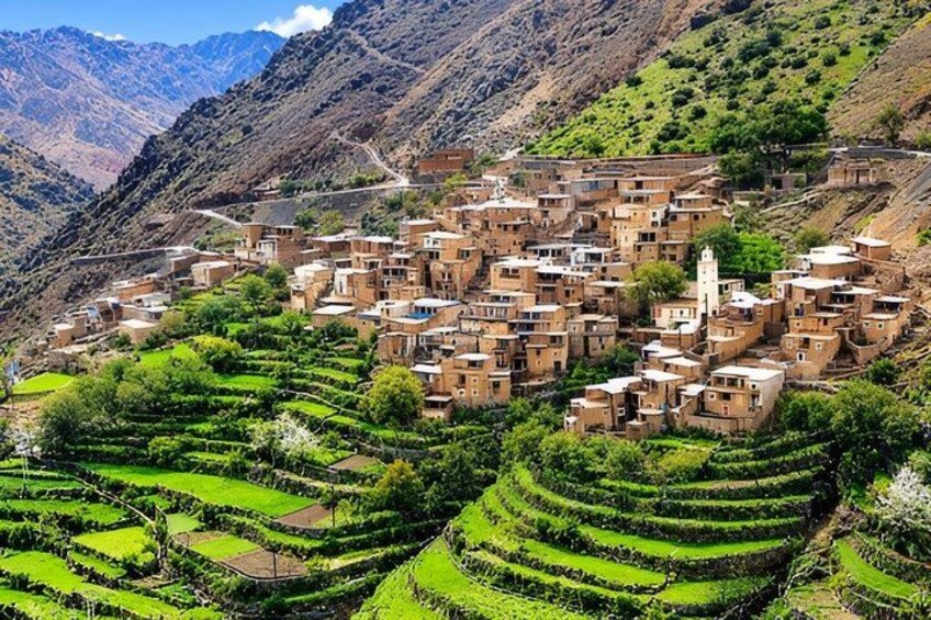 A terraced village nestled in a mountainous region with lush green fields and traditional buildings. 1