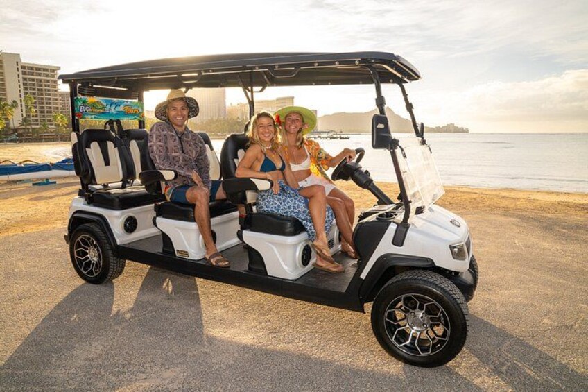 A golf cart on a beach with a city skyline in the background. 3