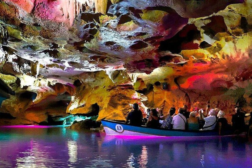 A cave with colorful rock formations and a boat tour. 4