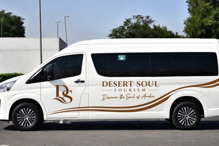 A white van with 'Desert Soul Tourism' branding and the tagline 'Discover the Soul of Arabia' on its side. 3