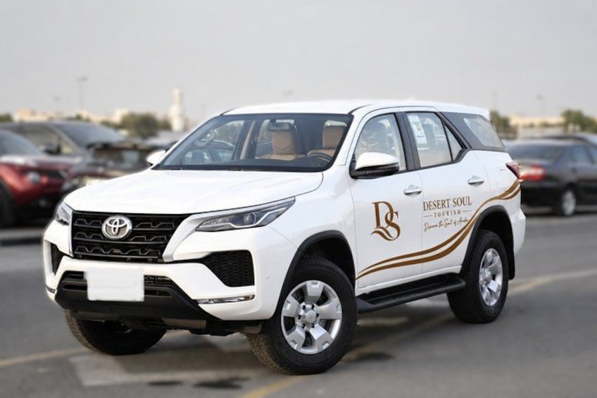 A white SUV with 'Desert Soul' branding parked in a lot. 1