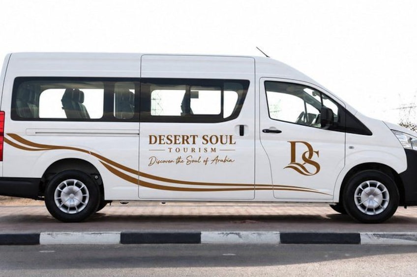 A white van with 'Desert Soul Tourism' branding and a logo on its side. 5