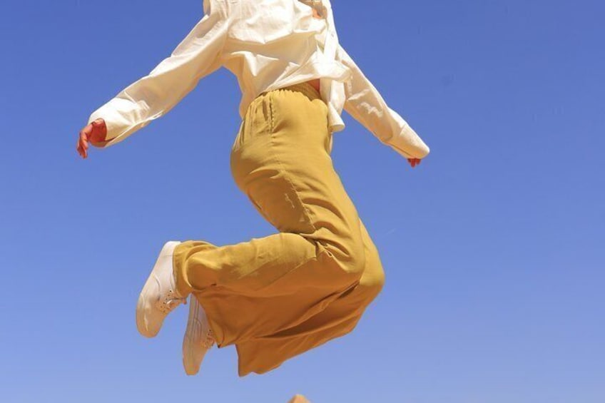 A person jumping against a clear blue sky. 4