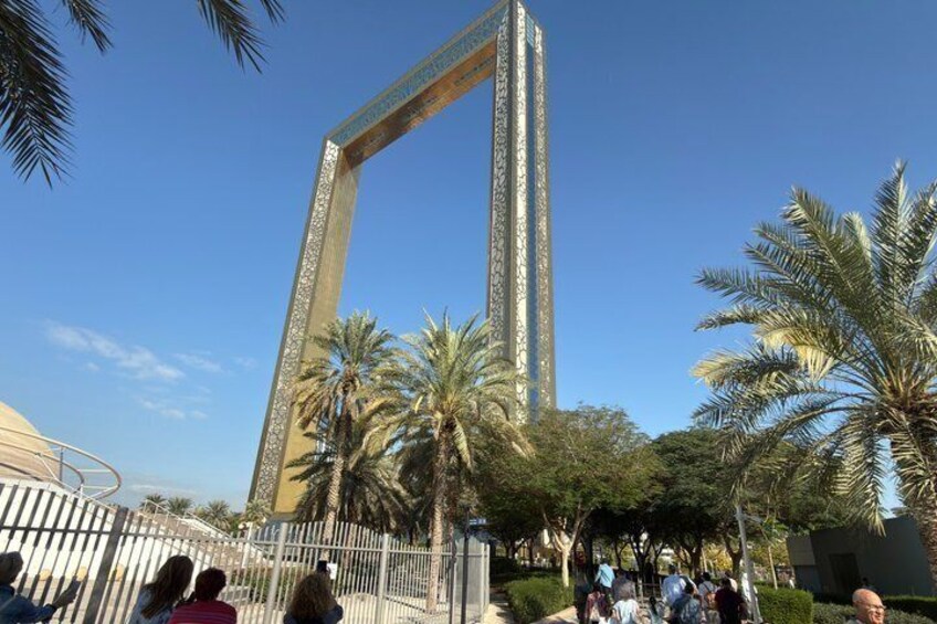 A tall, ornate tower with intricate designs, surrounded by palm trees and a clear blue sky. 2