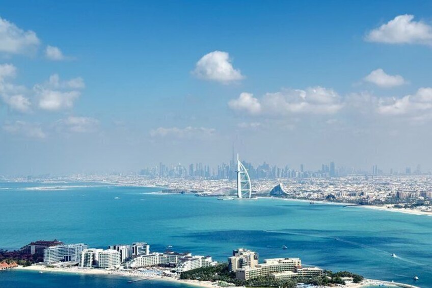 A coastal cityscape with a prominent bridge, clear blue waters, and a dense urban skyline. 3