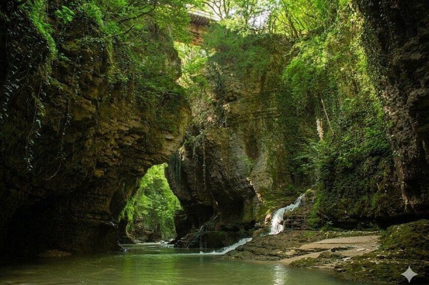 A natural cave with a waterfall and a river. 5