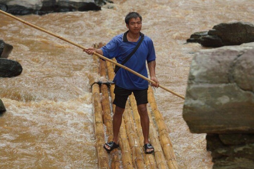 A person crossing a river on a bamboo raft using a long pole for support. 5