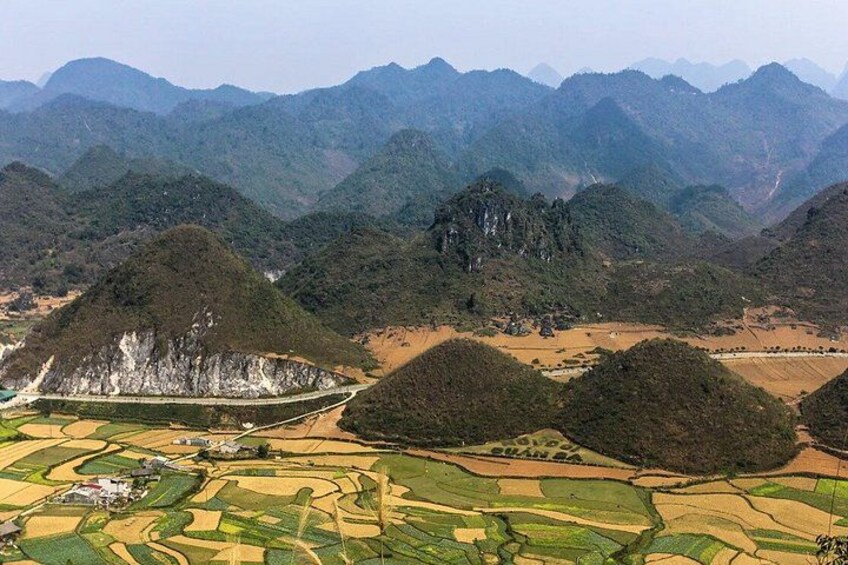 A mountainous landscape with terraced fields and a prominent rock formation. 2