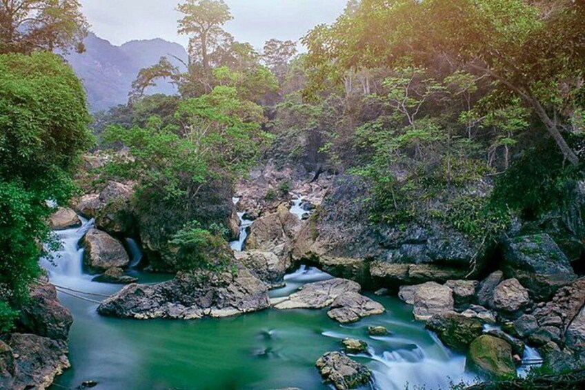 A river flowing through a rocky landscape with lush greenery and trees. 5