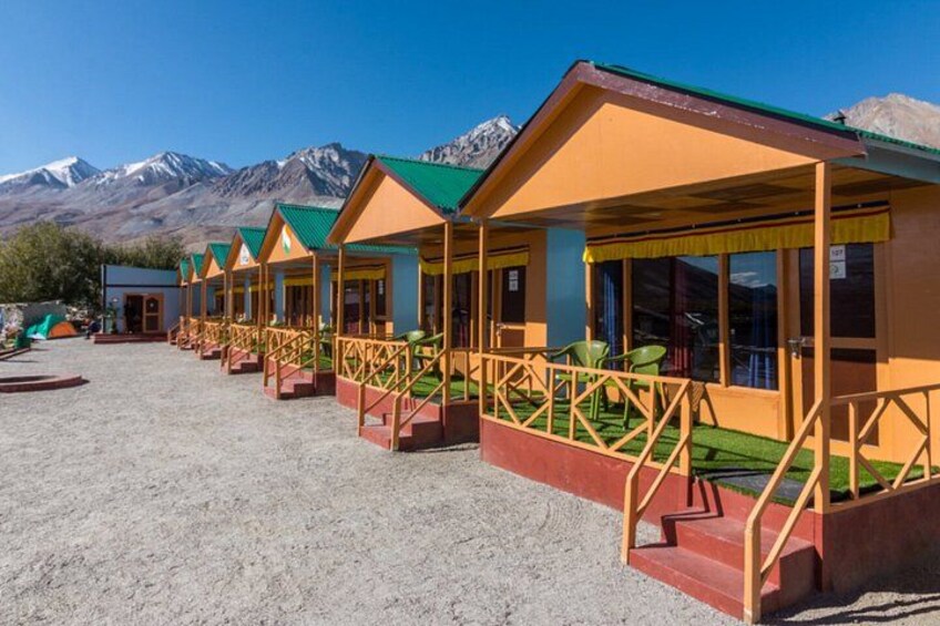 A row of colorful cabins with a mountainous backdrop. 1