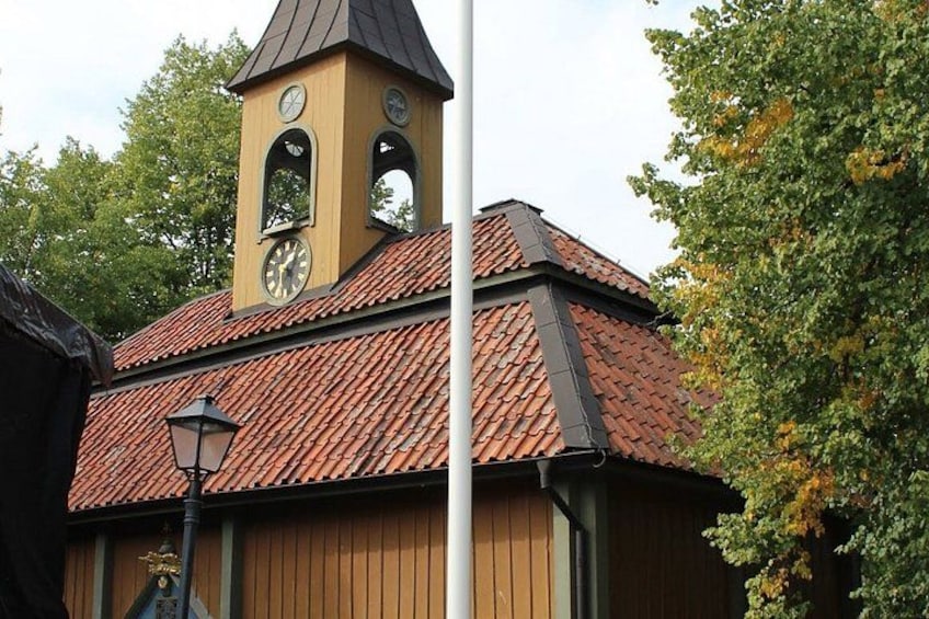 A building with a clock tower, red-tiled roof, and a lamppost. 3