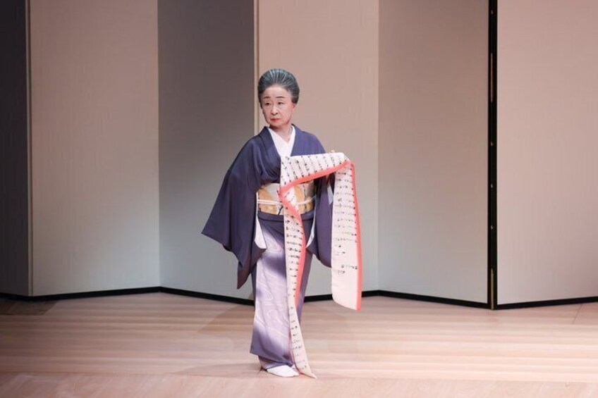 A person in traditional attire holding a scroll. 1