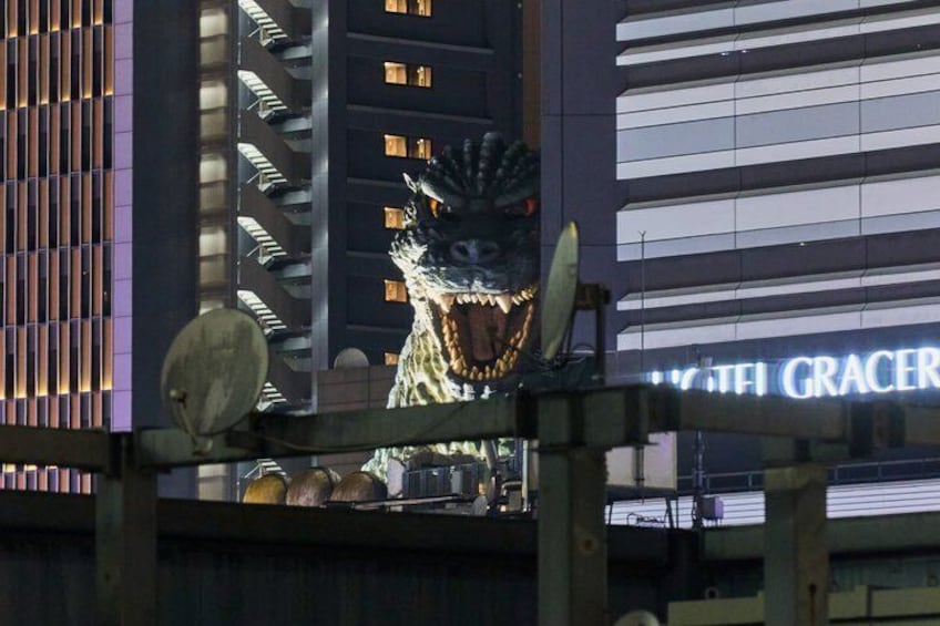 A dragon statue in front of a building with illuminated windows. 5