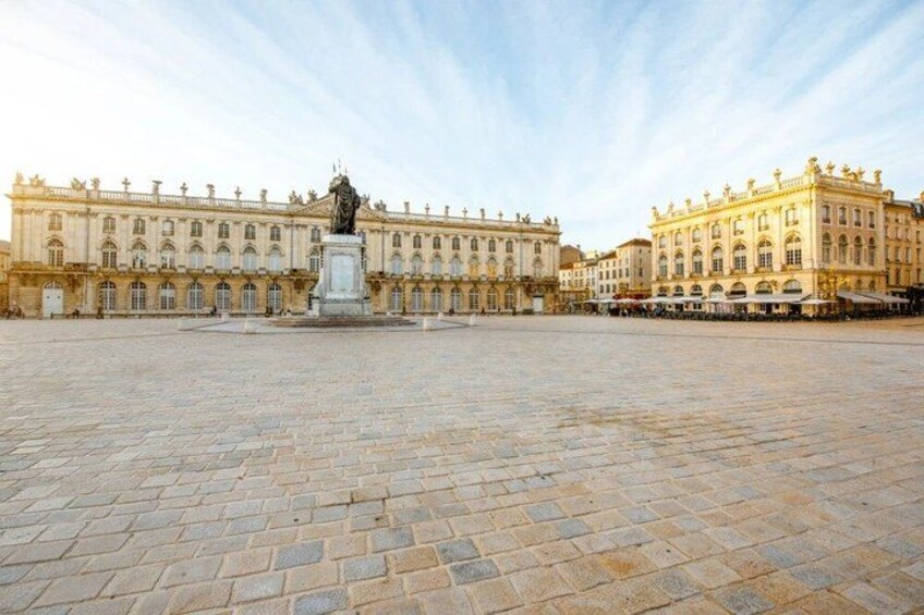 A large open courtyard with a statue in the center, surrounded by classical architecture. 5