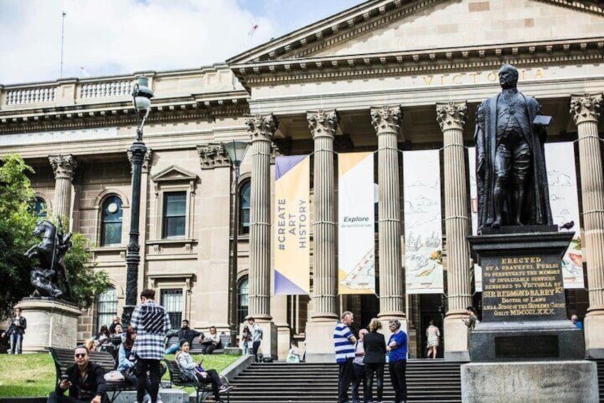 A classical building with columns, a statue, and banners. 3