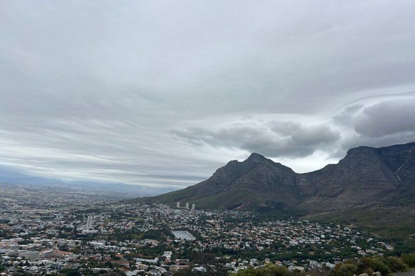 A mountainous landscape with a city in the foreground and a cloudy sky. 4