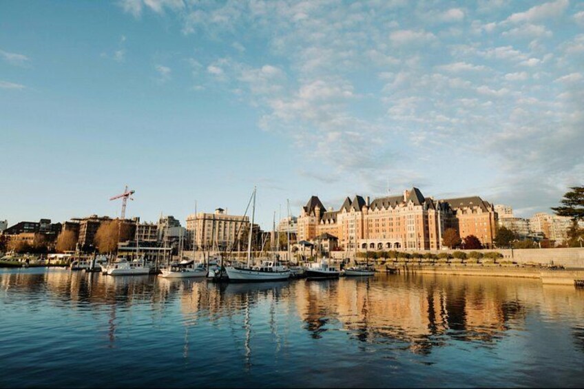 A waterfront with boats docked, a large building with a distinctive architectural style, and a clear sky. 2