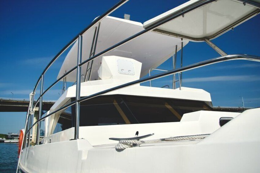 A white yacht with a covered deck and metal railings. 5