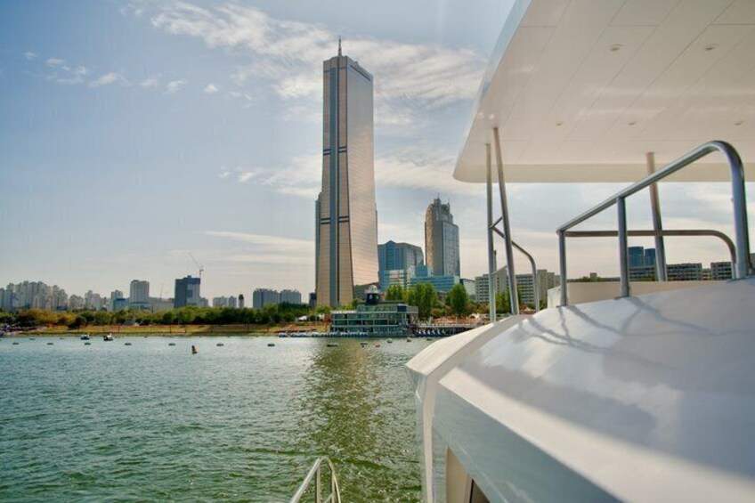 A modern building, a body of water, and a boat. 2