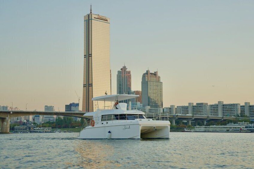A white boat on water with a city skyline in the background. 1