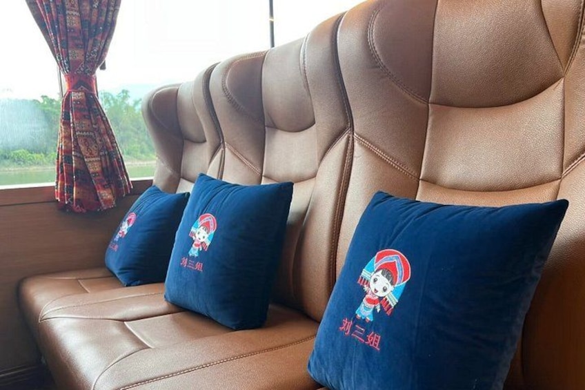 A brown leather sofa with three blue cushions featuring a cartoon character and text. 4