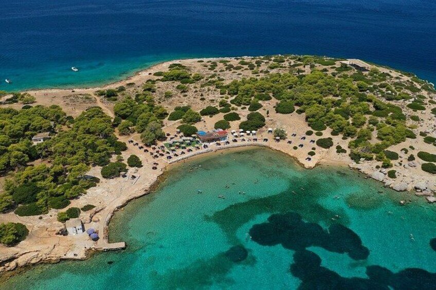 An aerial view of a coastal area with clear turquoise waters, a sandy beach, and scattered greenery. 2