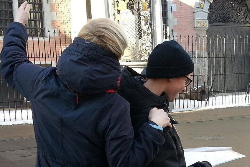 Two people standing on a sidewalk, one wearing a dark jacket and the other a beanie. 5