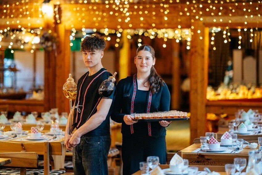 A restaurant interior with tables set for dining, string lights, and a person carrying a tray. 3