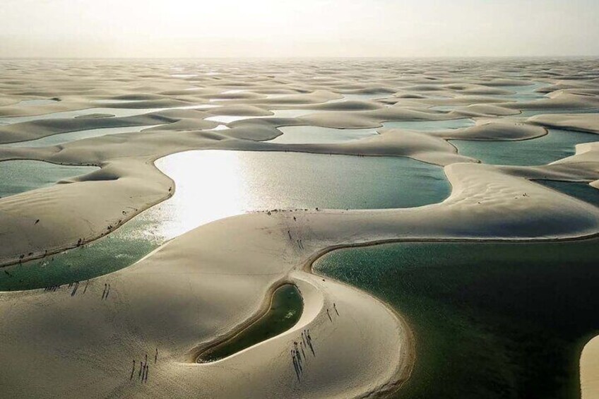 A vast desert landscape with sand dunes and interconnected water bodies. 5