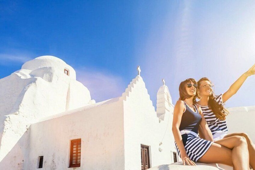 A couple on a rooftop with white buildings and a clear blue sky. 5