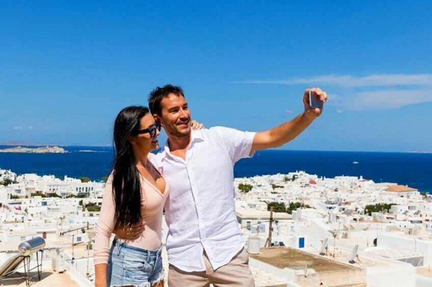 A couple taking a selfie with a coastal town in the background. 2