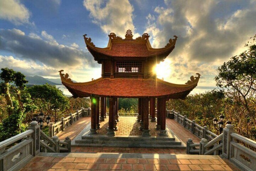 A traditional Chinese pavilion with ornate roof and columns, surrounded by a stone pathway and railing. 2