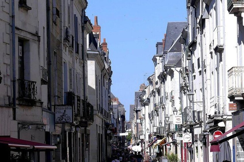 A narrow street lined with historic buildings, some with visible signage and architectural details. 4