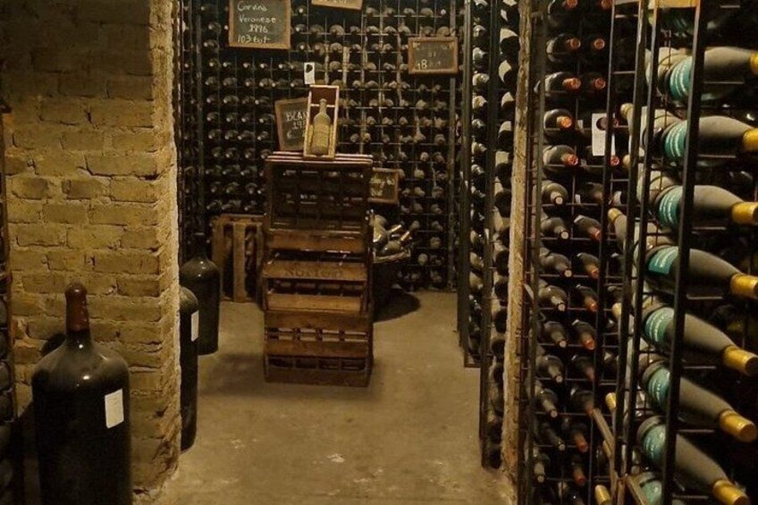 A wine cellar with rows of wine bottles on shelves and racks. 2