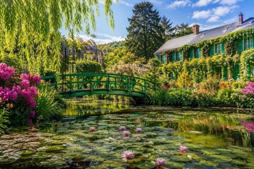 A green bridge over a pond with water lilies and flowering plants. 1