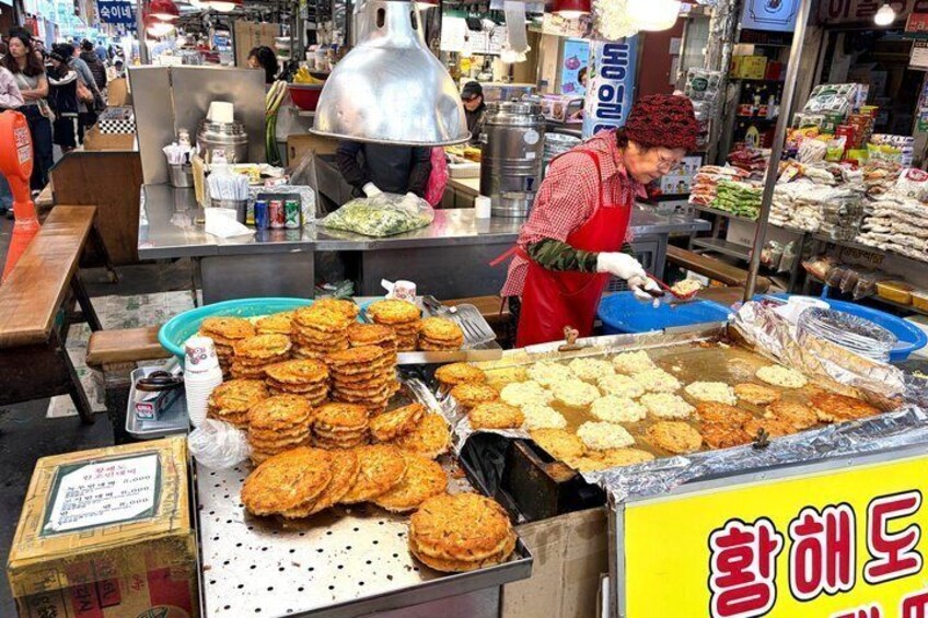 A street food vendor preparing food at a market stall. 3
