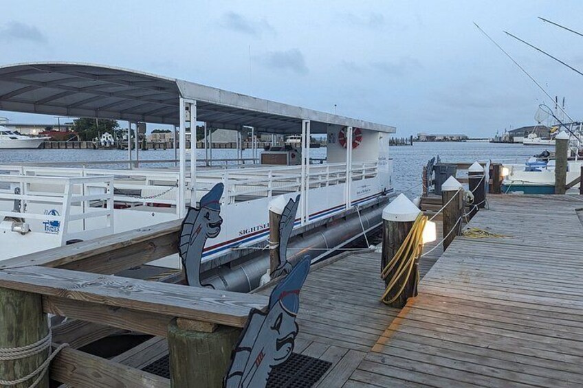 A dock with a boat, wooden planks, and a covered area. 3